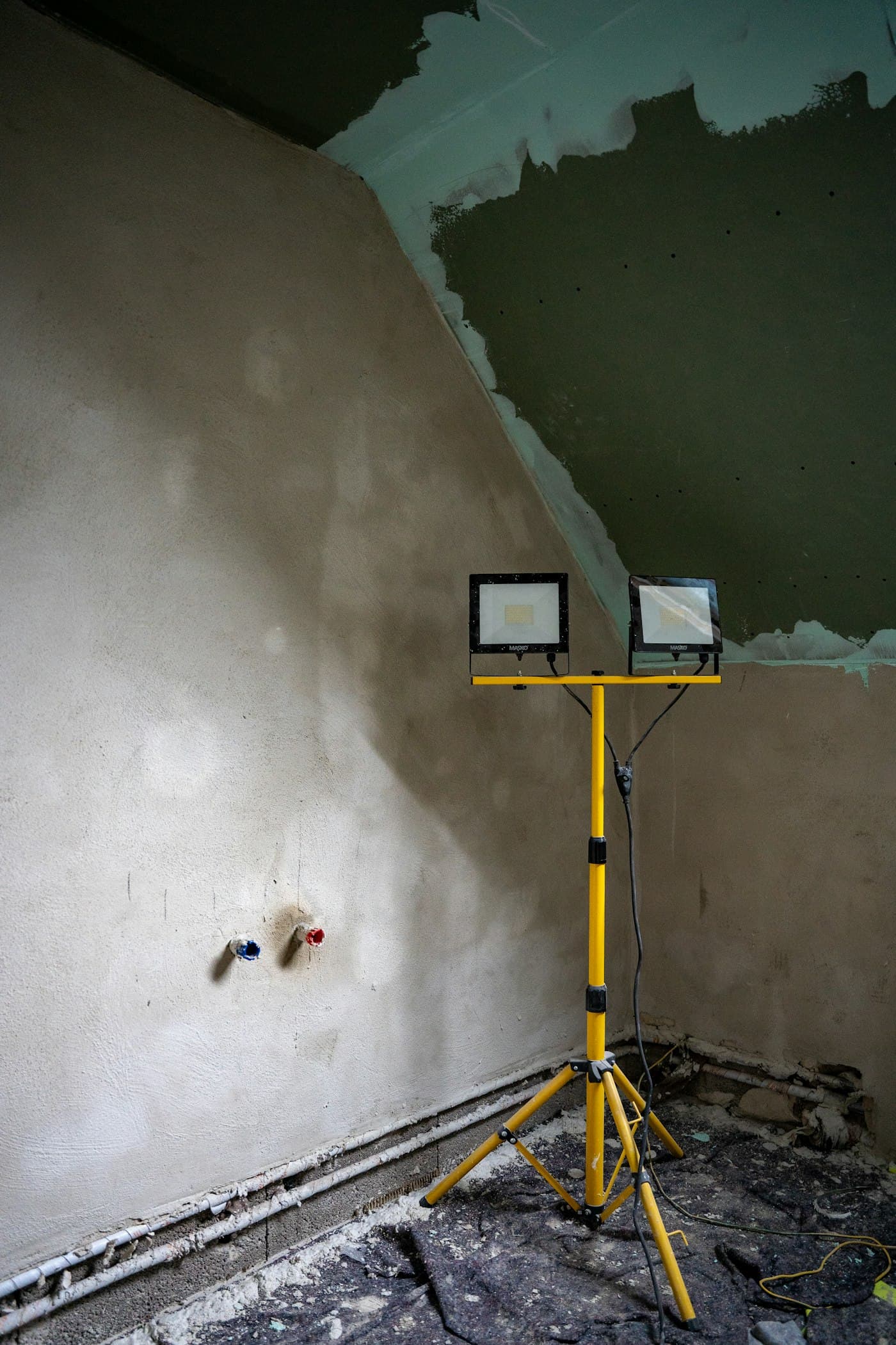 Verputzte Wand im Rohbau mit Baustrahler während des Innenausbaus